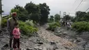 Orang-orang menyaksikan kerusakan yang disebabkan oleh tanah longsor setelah hujan deras di Khaniyara, dekat Dharmsala, India (2/9/2022). Tidak ada korban jiwa yang dilaporkan akibat musibah tersebut. (AP Photo/Ashwini Bhatia)