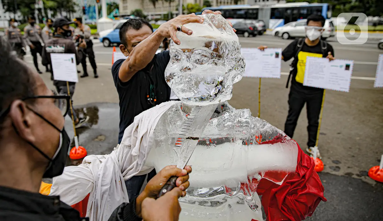 Aksi berupa patung es dalam pengantaran 1000 kartu pos oleh aktivis Greenpeace kepada Presiden Joko Widodo di kawasan Monumen Patung Kuda, Jakarta, Rabu (10/11/2021). Kartu pos itu berisikan agar pemerintah melihat dampak perubahan iklim terhadap ekosistem di sekitar. (Liputan6.com/Faizal Fanani)
