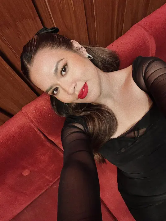 Cantiknya potret selfie Raisa pakai outfit hitam dengan makeup flawless; winged-eyeliner dan pulasan lipstik merah yang menonjol. [Foto: Instagram/raisa6690]
