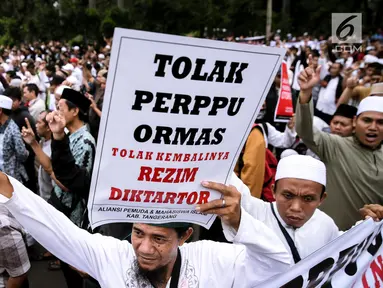 Peserta aksi membawa poster saat berunjuk rasa di Pintu Barat Monas, Jakarta, Selasa (18/7). Dalam aksinya mereka menilai Perppu Ormas menimbulkan tindakan diktator (kesewenang-wenangan). (Liputan6.com/Faizal Fanani)