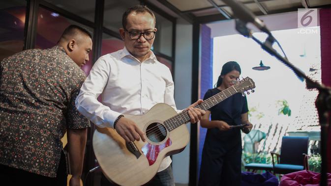 Menteri Ketenagakerjaan M. Hanif Dhakiri bersiap bernyanyi saat hadir menjadi bintang tamu dalam acara KLY Lounge di Gedung KLY, Gondangdia, Jakarta, Jumat (5/10). (Liputan6.com/Faizal Fanani)