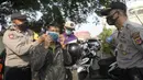 Anggota polisi dari Polsek Parung membantu memasangkan masker kepada pengendara sepeda motor di depan Polsek Parung, Kabupaten Bogor, Jawa Barat, Rabu (2/9/2020). Pembagian masker gratis setiap usai apel ini inisiatif anggota sejak masa pandemi COVID-19. (merdeka.com/Dwi Narwoko)