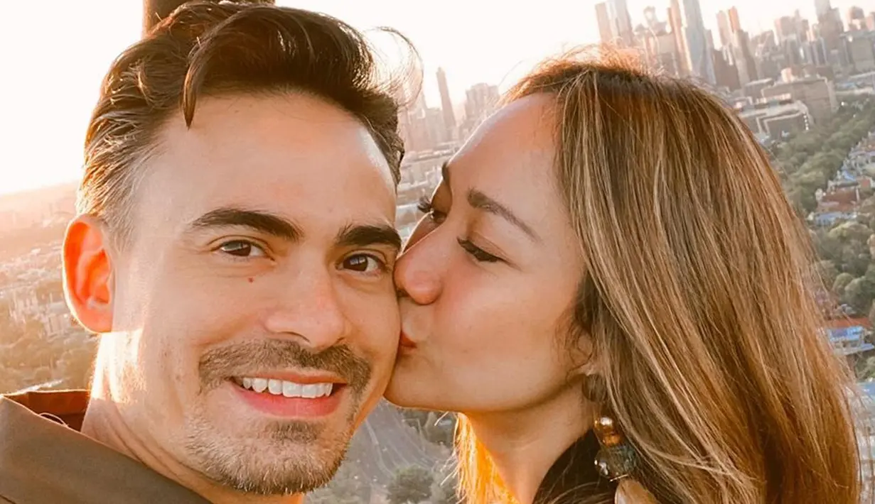 Penyanyi Bunga Citra Lestari mencium suaminya Ashraf Sinclair saat menaiki balon udara di Melbourne. Suami Bunga Citra Lestari, Ashraf Sinclair, meninggal dunia di usia 40 tahun diduga akibat serangan jantung pada Selasa 18 Februari 2020 pukul 3.40 pagi. (Instagram/@bclsinclair)