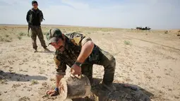 Anggota YBS yang berafiliasi dengan Partai Pekerja Kurdistan (PKK) menemukan ranjau  di sebuah jalur yang biasa dilintasi ISIS, Irak utara, 30 April 2016. Mereka juga berpatroli mencari ranjau darat yang dipasang ISIS sebelumnya. (REUTERS/Goran Tomasevic)