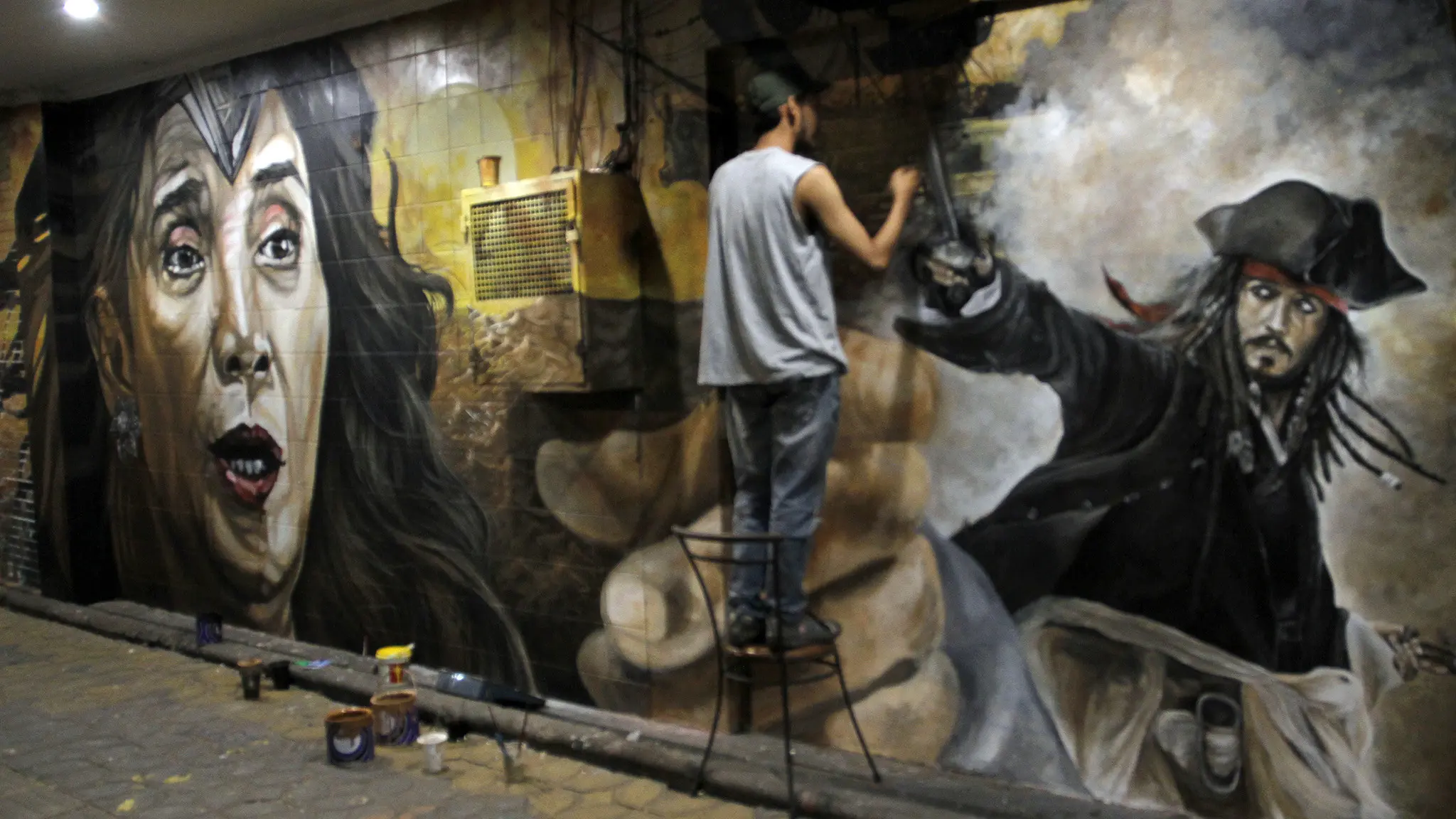 Sejumlah pelukis di Solo menggambar mural Menteri Kelautan dan Perikanan Susi Pudjiastuti bergaya Wonder Woman di tembok di Jalan Slamet Riyadi Solo, Jumat dini hari (18/8).(Liputan6.com/Fajar Abrori)
