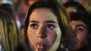 Harap-harap cemas menyelimuti hati seluruh pendukung Aljazair termasuk fans cantik yang satu ini, Senin (30/6/2014) (AFP PHOTO/FAROUK BATICHE)