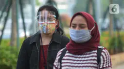 Seorang wanita yang mengenakan masker batik (kiri) berjalan di kawasan Thamrin Sudirman, Jakarta, Jumat (2/10/2020). Pada Hari Batik Nasional yang berlangsung di tengah pandemi COVID-19, sebagian masyarakat terlihat mengenakan baju dan masker dengan motif batik. (merdeka.com/Imam Buhori)