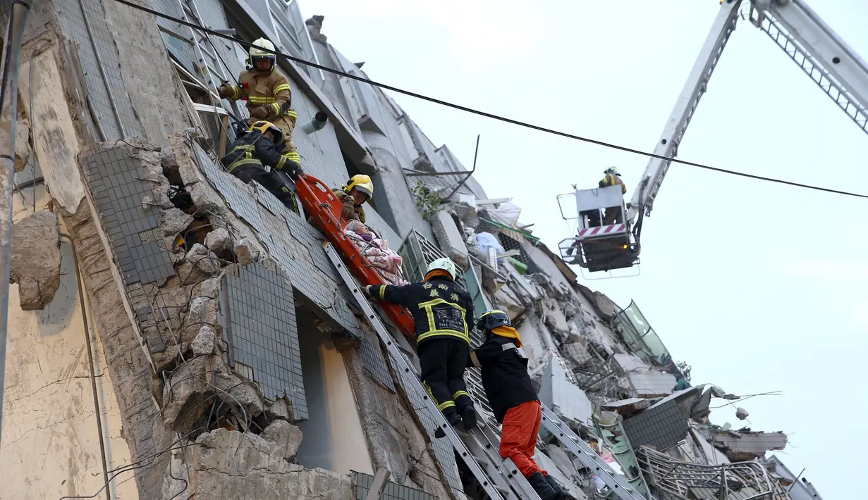 Tim penyelamat mengevakuasi warga yang berada dibangunan yang runtuh akibat 6,4 SR mengguncang Tainan di Taiwan, Sabtu (6/2). Gempa terjadi pukul 4 subuh tadi telah menghancurkan beberapa apartemen di kawasan Wei Guan, Tainan, Taiwan. (REUTERS/Stringer)