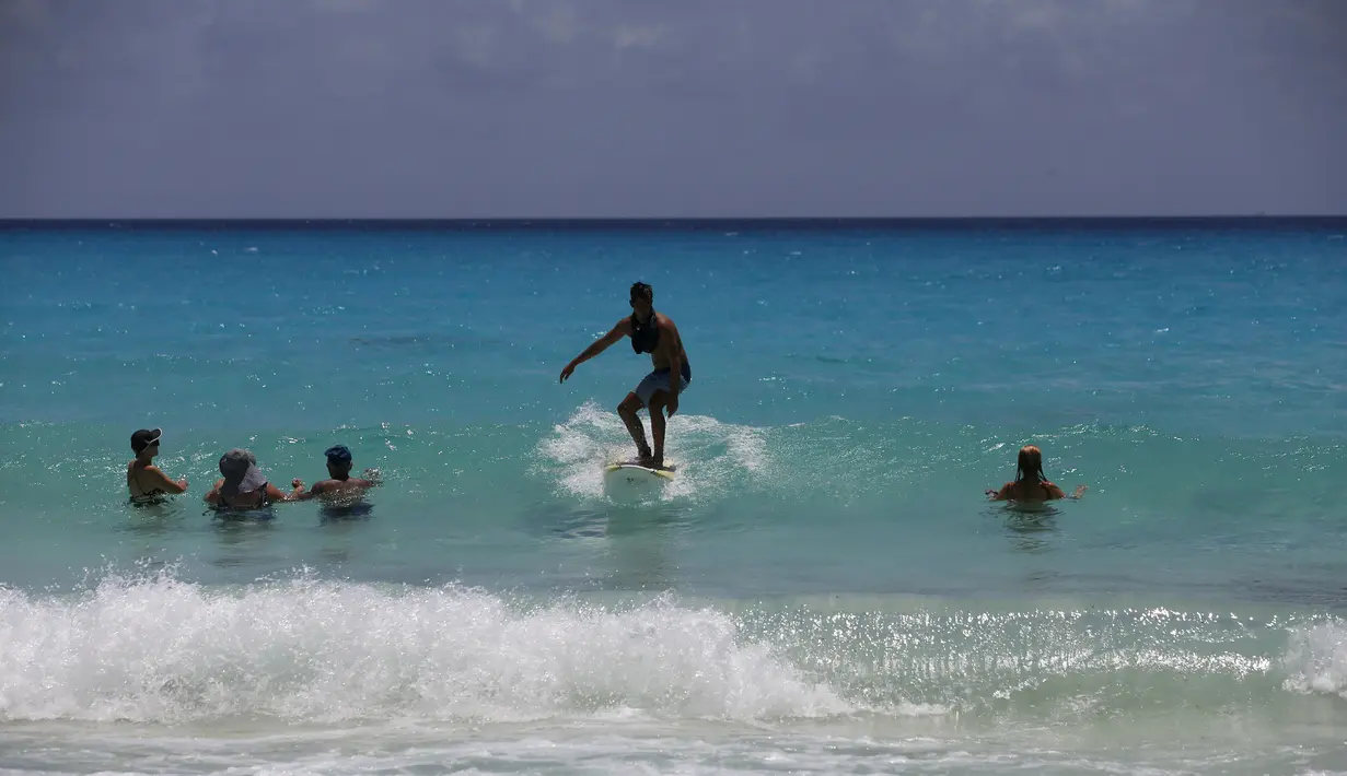 Wisatawan menikmati pantai sebelum kedatangan Badai Grace, di Cancun, Meksiko, Rabu (18/8/2021). Badai tropis Grace yang menguat menjadi badai pada 18 Agustus 2021 meluncur ke arah pantai Karibia, Meksiko dan mengancam akan membawa hujan lebat, banjir bandang dan gelombang besar. (AP/Marco Ugarte)