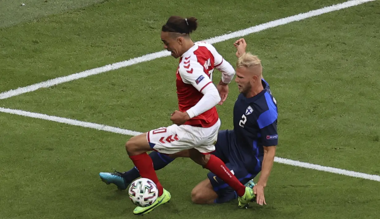 Bek timnas Finlandia, Paulus Arajuuri menghentikan penyerang Denmark, Yussuf Poulsen pada laga Grup B Euro 2020 di Parken Stadium, Sabtu (12/6/2021). Selain tumbang 0-1, tuan rumah juga terpukul menyusul insiden yang melibatkan Christian Eriksen.  (Friedemann Vogel/Pool via AP)