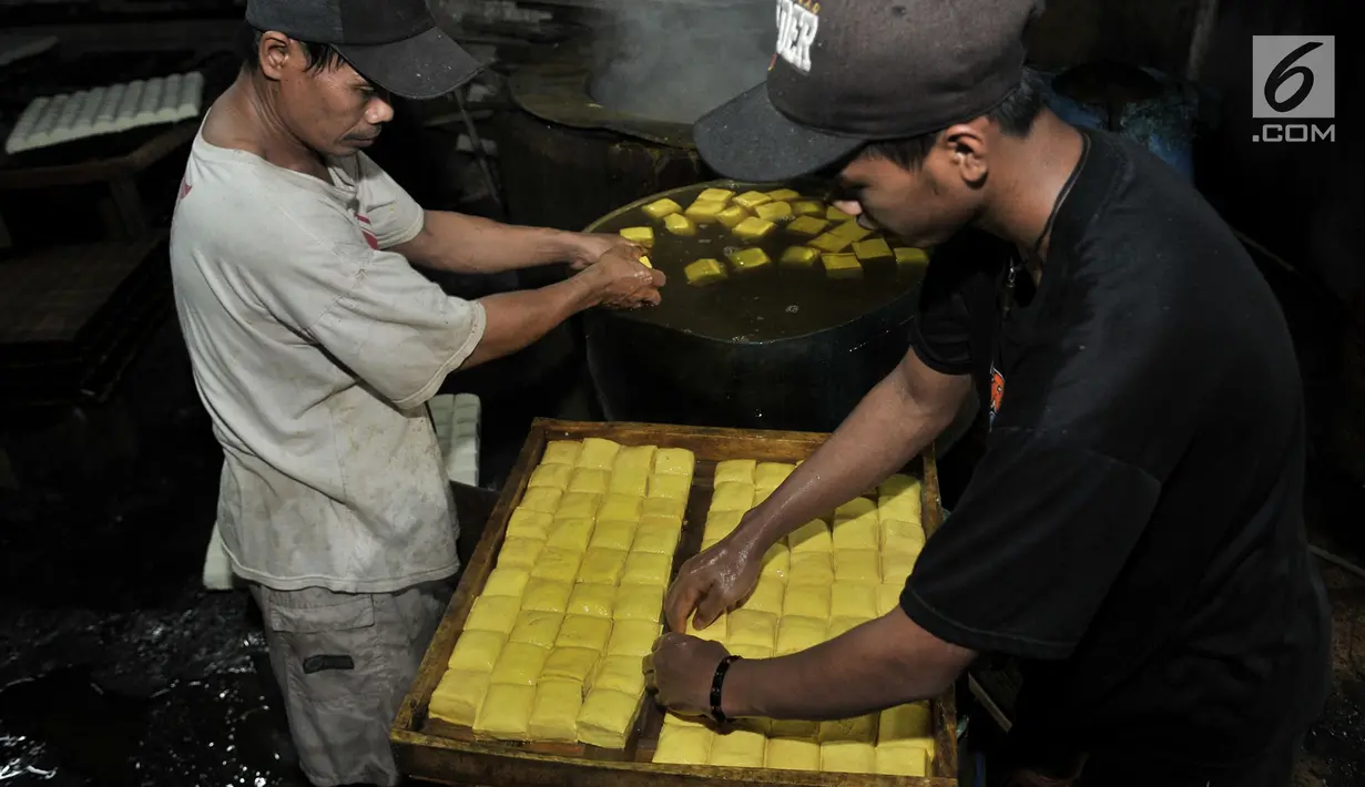Pekerja menyelesaikan pembuatan tahu di salah satu industri rumahan Semanan, Kalideres, Jakarta, Rabu (19/9). Naiknya dolar AS membawa dampak pada harga kedelai impor yang merupakan bahan baku para produsen tahu di Semanan. (Merdeka.com/Iqbal S Nugroho)