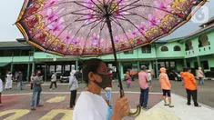 Warga antre dengan mengikuti physical distancing untuk mendapatkan bantuan beras di Makodim 0506 Tangerang, Banten, Senin (27/4/2020). Program bantuan melalui ATM Pertanian Si Komandan memiliki kapasitas muat 180 kilogram dengan waktu operasi selama 12 jam per hari. (Liputan6.com/Fery Pradolo)