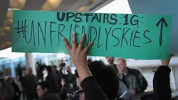 Demonstran mengecam tindakan polisi yang mengeluarkan penumpang tidak manusiawi di pesawat United Airlines di Bandara Internasional O'Hare, Chicago, AS, Selasa (11/4). (Scott Olson / Getty Images / AFP)