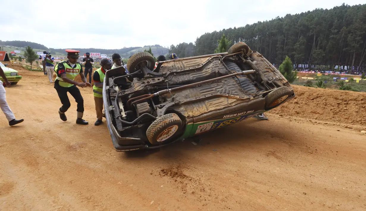 Seorang polisi dan petugas mobil balap bergegas menuju mobil yang terbalik, sebelum kecelakaan lain yang menewaskan beberapa orang di Diyatalawa, Sri Lanka, Minggu (21/4/2024). (AP Photo)