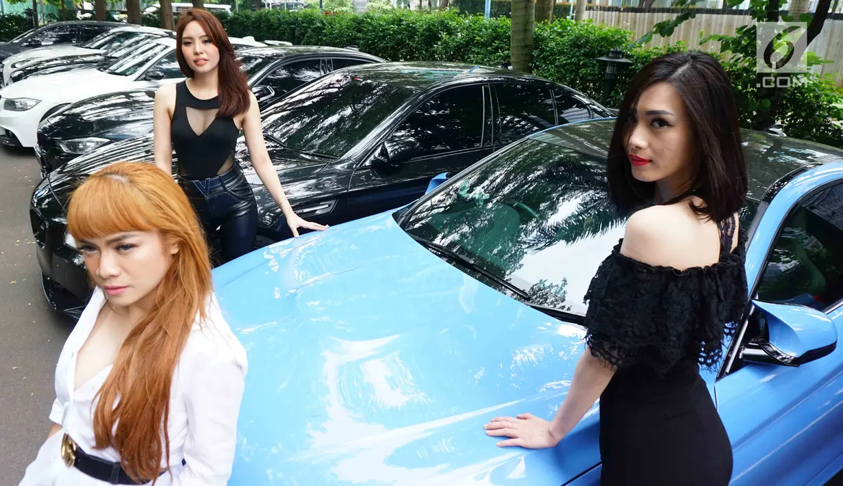 Tiga model berpose diantara mobil BMW F Series dalam acara 4th Komunitas BMW F Series di Jakarta, Sabtu (24/3). Komunitas F Series dibentuk sebagai wadah bertukar pikiran antara anggota khususnya modifikasi. (Liputan6.com/Pool/Bio)