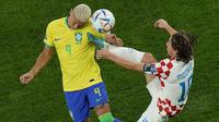 Pemain Timnas Kroasia, Luka Modric (kanan) berebut bola dengan pemain Timnas Brasil, Richarlison dalam laga babak perempatfinal Piala Dunia 2022 di Education City Stadium, Al Rayyan, Qatar, Jumat (9/12/2022) malam WIB. (AP/Alessandra Tarantino)