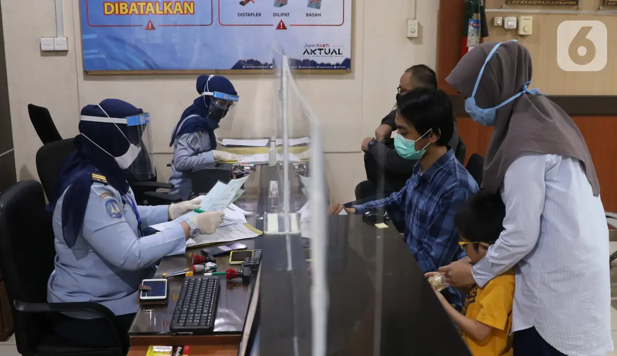 Petugas dengan mengenakan masker dan pelindung wajah melayani pemohon paspor di Kantor Imigrasi Kelas I Non TPI Tangerang, Senin (15/6/2020). Memasuki masa tatanan normal baru, pelayanan keimigrasian untuk warga mulai aktif kembali dengan menerapkan protokol kesehatan. (Liputan6.com/Angga Yuniar)