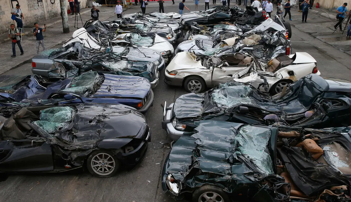 Puluhan mobil mewah usai dilindas buldoser saat peringatan ulang tahun Biro Bea Cukai Filipina ke-116 di Metro Manila, Filipina, (6/2). Mobil-mobil tersebut merupakan hasil dari kasus penyelundupan. (AP Photo/Bullit Marquez)