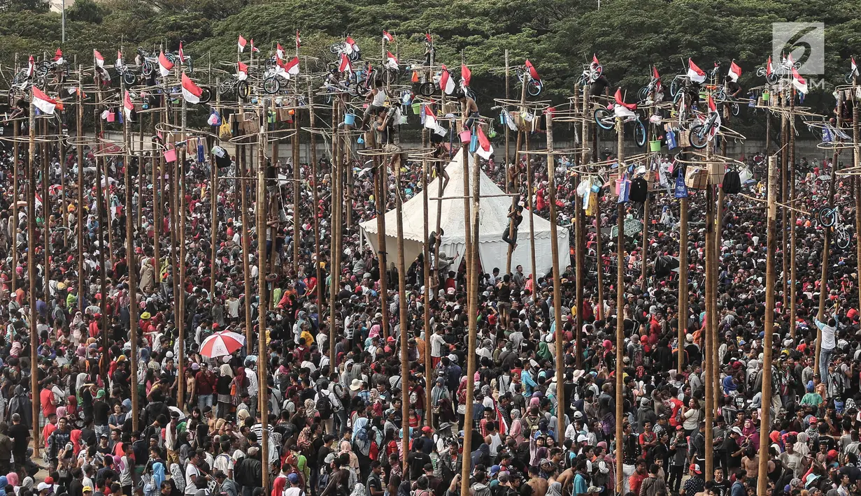 Suasana lomba panjat pinang Kolosal dalam rangka merayakan HUT ke 72 RI di Pantai Karnaval Ancol, Jakarta, Kamis (17/8). Sebanyak 172 batang pohon pinang disediakan untuk warga dengan berbagai macam hadiah menarik. (Liputan6.com/Faizal Fanani)
