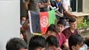 Pengungsi Afghanistan mengibarkan bendera negaranya untuk menunjukkan identitasnya di sebuah kamp pengungsi di Bekasi, Jawa Barat (20/8/2021). Mereka tidak bersedia kembali ke negaranya, terutama setelah Taliban mengambil alih kekuasaan dari pemerintahan Presiden Ashraf Ghani. (AFP/Bay Ismoyo)