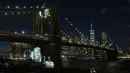 Gambar korban diproyeksikan pada Jembatan Brooklyn saat Hari Peringatan COVID-19 di Brooklyn, New York, Amerika Serikat, 14 Maret 2021. Kota New York mencatatkan kematian tertinggi akibat virus corona COVID-19 di Amerika Serikat. (Kena Betancur/AFP)