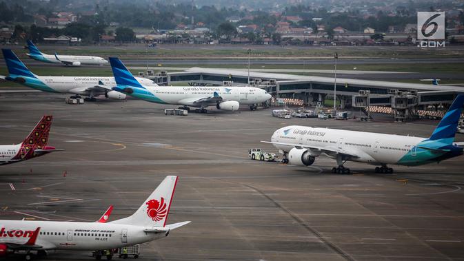 Pesawat maskapai Garuda Indonesia terparkir di areal Bandara Soekarno Hatta, Tangerang, Banten, Kamis (16/5/2019). Pemerintah akhirnya menurunkan tarif batas atas (TBA) tiket pesawat atau angkutan udara sebesar 12-16 persen yang berlaku mulai Kamis hari ini. (Liputan6.com/Faizal Fanani)