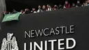 Pendukung Newcastle United membawa bendera Arab Saudi saat merayakan di luar St. James'Park di Newcastle Upon Tyne, Inggris (7/10/20210). Newcastle mengumumkan pembelian klub oleh Public Investment Fund (PIF), Kamis (7/10/2021) malam WIB. (AP Photo / Scott Heppell)