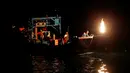 Nelayan Taiwan saat mencari ikan menggunakan api sebagai umpan di perairan New Taipei City, Taiwan, (19/6). Kini Metode tradisional ini hanya digunakan segelintir nelayan dan tersisa tiga kapal saja setiap malam. (REUTERS/Tyrone Siu)