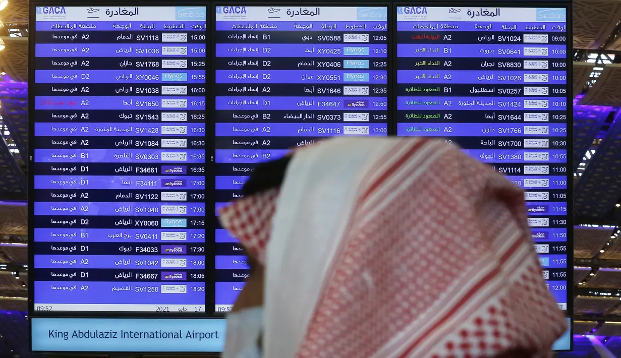 Sebuah layar menampilkan jadwal keberangkatan dalam negeri dan internasional di Bandara Internasional King Abdulaziz, Jeddah, Senin (177/5/2021). Warga Saudi yang divaksinasi Covid-19 diizinkan bepergian ke luar negeri menyusul dicabutnya larangan perjalanan. (AP Photo/Amr Nabil)