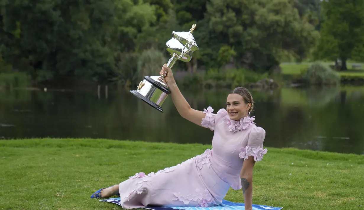 Aryna Sabalenka dari Belarusia berpose dengan trofi kejuaraan tenis Australia Open 2023 di Royal Botanic Garden di Melbourne, Minggu (29/1/2023). Kemenangan ke-11 berturut-turut tahun ini juga membawa Sabalenka kembali ke peringkat kedua WTA di belakang Iga Swiatek dari Polandia. (AP Photo/Dita Alangkara)
