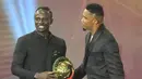 Mantan penyerang Kamerun Samuel Eto'o (kanan) memberi selamat kepada penyerang Senegal Sadio Mane (kiri) setelah memenangkan penghargaan Pemain Terbaik Afrika 2019 selama CAF Awards di kota wisata Mesir, Hurghada (7/1/2020). (AFP/Khaled Desouki)
