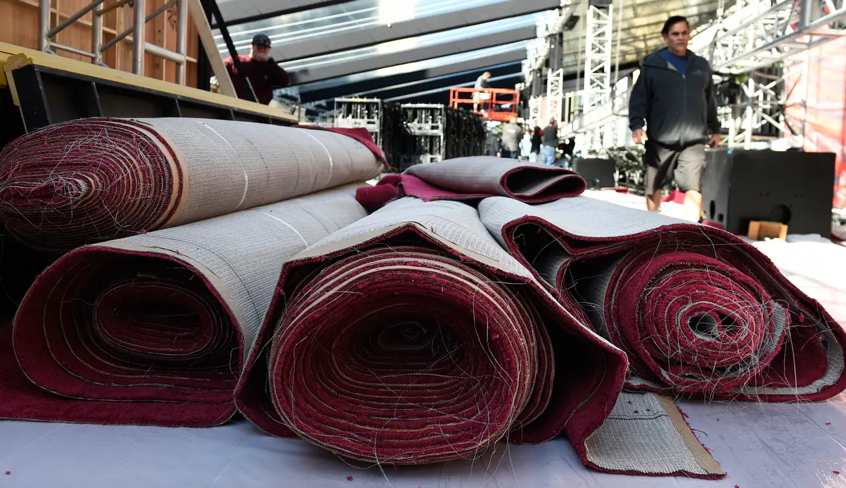 Petugas melewati gulungan karpet merah untuk gelaran Academy Awards ke-90 di Dolby Theatre, California, Rabu (28/2).  Ajang Piala Oscar ini digelar di Dolby Theatre Hollywood yang sudah menjadi langganan sejak 2002.  (Chris Pizzello/Invision/AP)