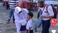Sepasang orangtua di Malaysia antar anaknya pada hari pertama sekolah dengan menggunakan seragam, sebagai bentuk motivasi bersekolah untuk anaknya. (Dok. Screenshot TikTok @kosmoonline)