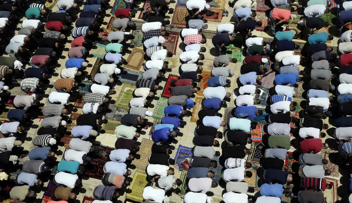 Jemaah muslim Palestina melaksakan salat di depan Kubah Shakhrah yang berada di tengah kompleks Masjid Al Aqsa, Yerusalem (8/6). Masjid Al Aqsa ini merupakan salah satu tempat suci dan penting bagi umat muslim. (AP/Mahmoud Illean)