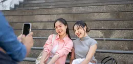 Ilustrasi dua perempuan sedang foto bersama. (cr: BongkarnGraphic/Depositphotos)