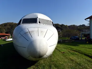 Badan pesawat Fokker-100 terlihat diparkir di halaman rumah warga setempat di Strmec Stubicki, dekat Zagreb, Kroasia, 26 Oktober 2019. Robert Sedlar (50) mengubahnya menjadi objek wisata di mana pesawat bisa disewakan untuk semua jenis acara dan pesta. (Denis LOVROVIC/AFP)
