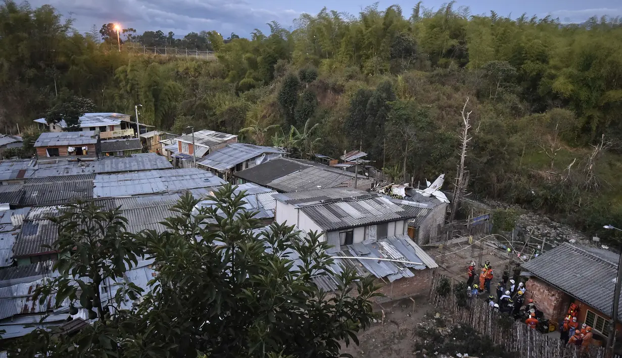 Tim penyelamat berada di lokasi jatuhnya sebuah pesawat kecil di tengah-tengah rumah penduduk di Popayan, Kolombia, Minggu (15/9/2019). Pemadam kebakaran mengatakan tiga orang luka parah, salah satunya adalah seorang anak yang merupakan warga setempat. (Luis ROBAYO / AFP)