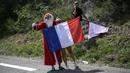 Penonton menggunakan seragam Santa Claus dan membawa bendera Prancis saat memberikan dukungan kepada pebalap Tour de France pada etape ke-19 dengan  jarak tempuh 222,5 km dari Embrun menuju Salon-de-Provence, Prancis, (21/7/2017). (AFP/Lionel Bonaventure)