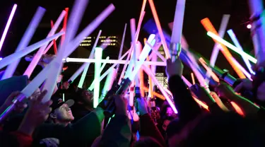 Penggemar film Star Wars berkumpul sambil membawa lightsaber (pedang sinar) saat mengikuti Glow Battle Tour di Grand Park, Los Angeles (15/12). Mereka berkumpul dengan membawa pedang sinar yang beraneka warna. (Photo by Chris Pizzello/Invision/AP)