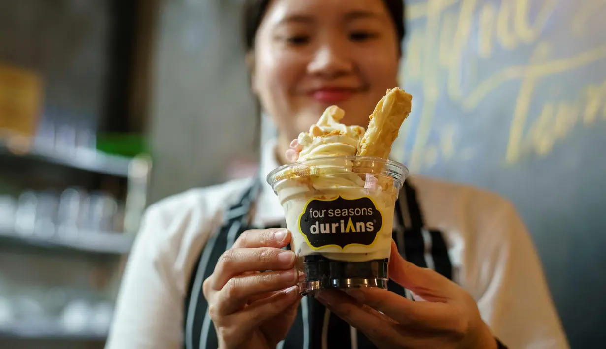 Seorang anggota staf restoran menunjukkan secangkir es krim rasa durian di kafe Mao Shan Wang di Singapura (24/1). (AFP Photo/Nicholas Yeo)