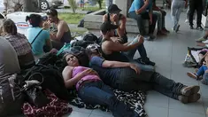 Sejumlah imigran Kuba beristirahat di luar gedung bea cukai di perbatasan antara Nikaragua dan Kosta Rika, Minggu (15/11). Nikaragua menutup perbatasannya dengan Kosta Rika hingga ribuan orang yang menuju Amerika terlantar. (REUTERS/Oswaldo Rivas)