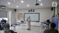 Terapis atau pengajar membimbing mahasiswa berkebutuhan khusus dalam proses pembuatan telur asin saat kelas terapi mata kuliah wirausaha di Lembaga Pendidikan dan Keterampilan Kampusnya Manusia, Kranggan, Bekasi, Jawa Barat, Kamis (3/12/2020). (merdeka.com/Iqbal S. Nugroho)