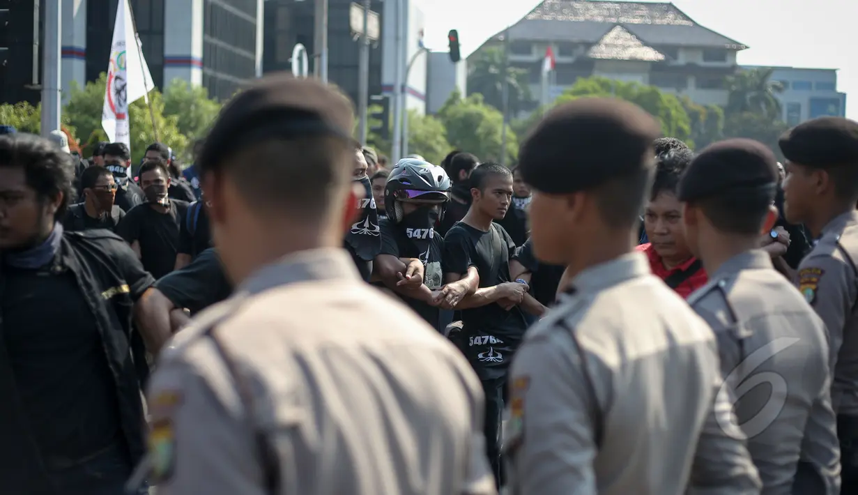 Petugas Kepolisian tampak berjaga saat aksi menolak lupa di depan Istana Merdeka, Jakarta, Selasa (12/5/2015). Mereka menuntut pemerintah untuk mengusut tuntas kasus Tragedi 12 Mei 1998 yang menewaskan 4 mahasiswa Trisakti. (Liputan6.com/Faizal Fanani)