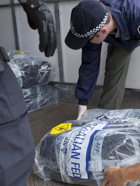 Polisi federal memindahkan paket kokain yang berhasil disita dari sebuah yacht di Sydney, Senin (6/2). Penyitaan kokain lebih dari 1 ton ini merupakan yang terbesar ditemukan dalam operasi narkoba oleh Australia. (STR/Australian Federal Police/AFP)