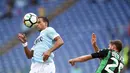 Gelandang Lazio, Ricardo Kishna (kiri) melakukan duel udara dengan pemain Sassuolo, Domenico Berardi pada lanjutan Serie A di Olympic Stadium, Roma, (1/10/2017). Lazio menang telak 6-1. (AFP/Filippo Monteforte)