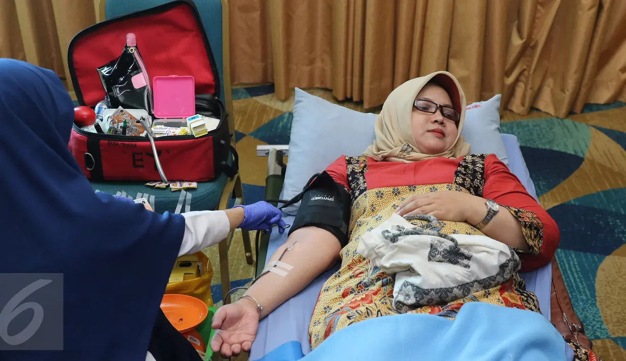 Seorang wanita melakukan donor darah di kawasan Senayan, Jakarta, Rabu (13/4). Dalam kegiatan tersebut Senayan City juga mengkampanyekan gaya hidup sehat dengan olahraga. (Liputan6.com/Herman Zakharia)