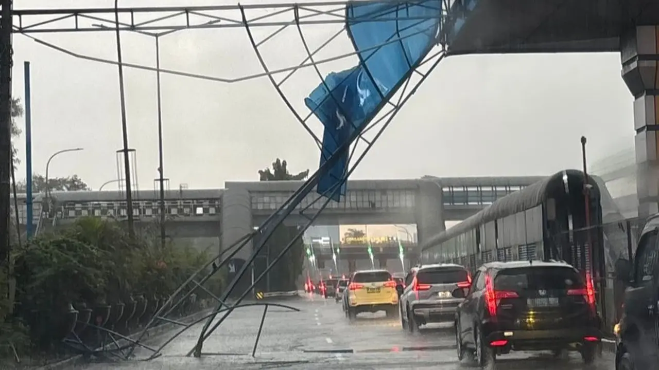 Hujan deras yang disertai angin kencang yang melanda Jakarta membuat rangka papan iklan di area Gerbang Tol Halim 2 Jalan Tol Dalam Kota roboh.
