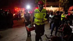 Tim penyelamat membawa peralatan menuju ke garasi parkir bawah tanah yang runtuh di sebuah kompleks di Mexico City (10/4). Petugas juga menggunakan anjing pelacak untuk mencari korban. (AP Photo/Rebecca Blackwell)