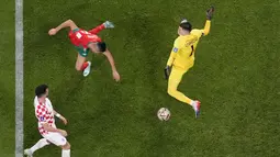 Dua menit berselang Achraf Dari (tengah) berhasil menyundul bola dan mengelabui penjaga gawang Kroasia, Dominik Livakovic (kanan). (AP Photo/Pavel Golovkin)
