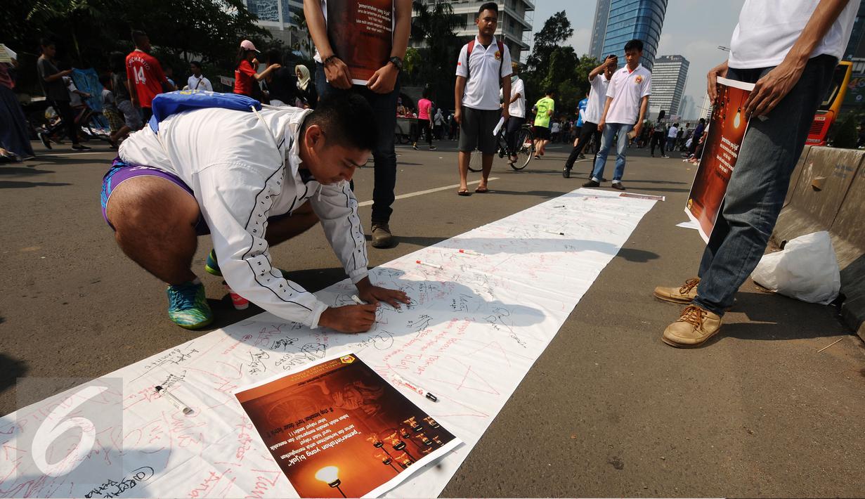 Warga menandatangani Petisi Penolakan Kenaikan Tarif Dasar Listrik di kawasan Bundaran HI, Jakarta, Minggu (7/5). Mereka menolak kebijakan kenaikan tarif dasar listrik yang diberlakukan per 1 Mei lalu. (Liputan6.com/Helmi Fithriansyah)
